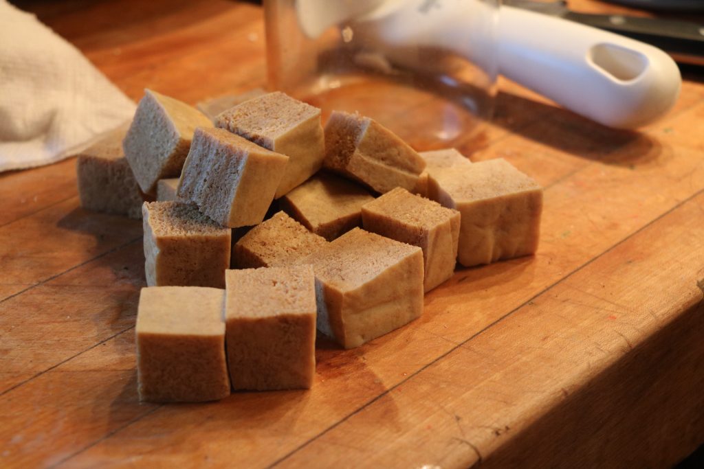 crispy fried tofu soaked in vegetarian 'beef' broth ready to be coated in cornstarch.