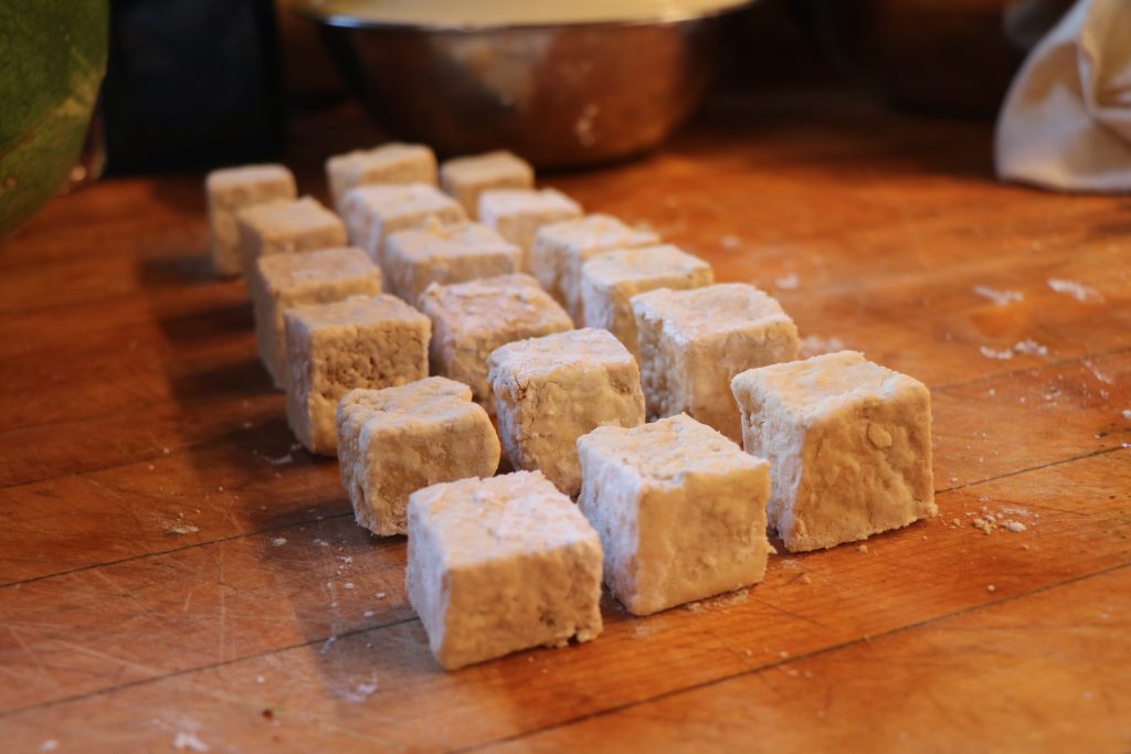 raw crispy fried tofu sitting on chopping board